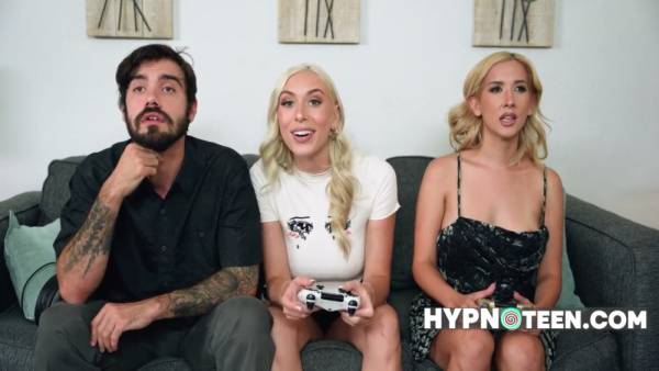 Two blonde babes under hypnosis yield to a tattooed man during an addictive game on adultfans.net
