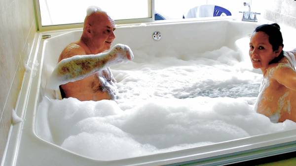 Slovakian woman and older man share a foamy nude bath in sunlit bathroom - Slovakia on adultfans.net