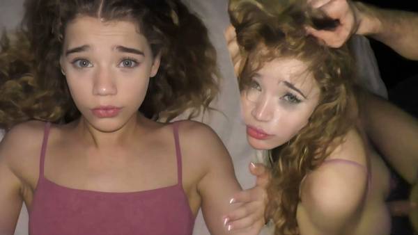 Curly-haired college girl takes cumshot deep in her mouth on a dimly lit bed on adultfans.net