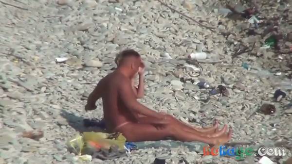 Tanned couple in pink thongs take their anal play to a rocky public beach on adultfans.net