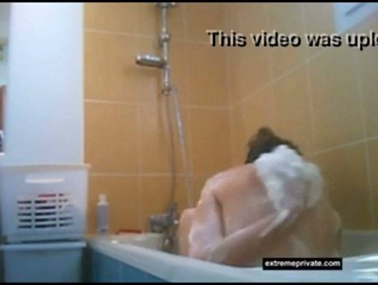 Hidden camera captures a nude figure bathing and leaning over the tub on adultfans.net