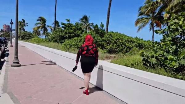 Curvy woman in red headscarf urinates on car door while Arab man jerks off nearby on adultfans.net