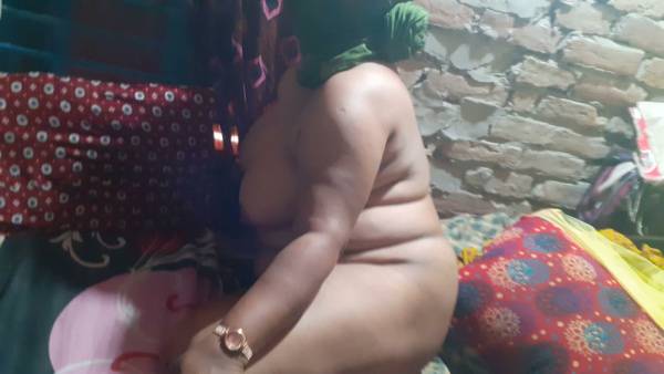 Plus-sized Black woman with huge tits and purple hair enjoys herself on a bed on adultfans.net