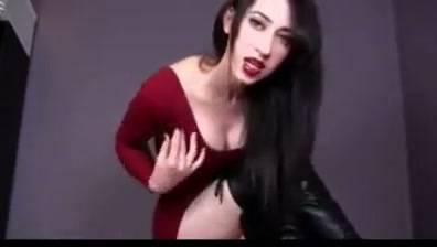 Confident woman in red dress gives herself a facial in a dark studio on adultfans.net
