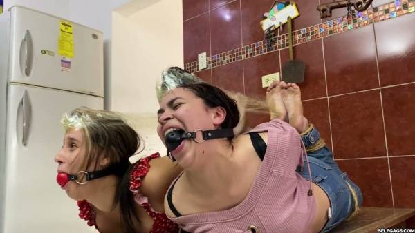 Two bound and gagged women restrained in tight rope bondage on wooden tables - Spain on adultfans.net