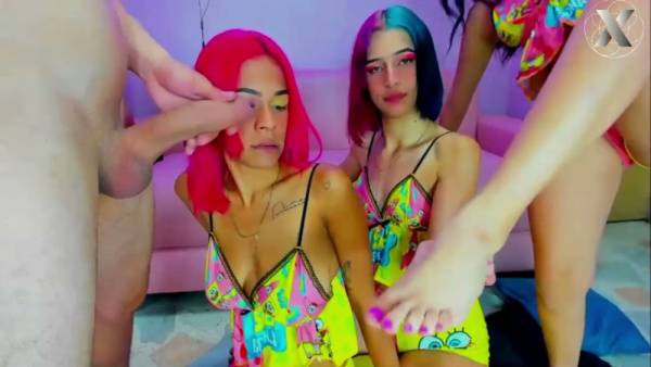 Three women with colorful hair in cartoon dresses take turns on a man's cock on adultfans.net