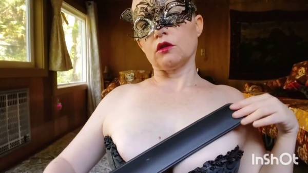 Strict dominatrix in black corset and mask disciplines with paddle and flogger on adultfans.net