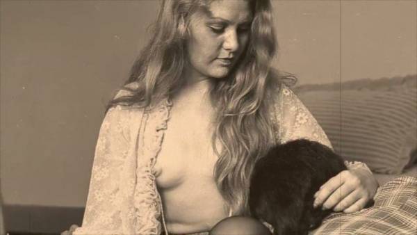 Vintage blonde receives oral sex from shirted man on a patterned bed on adultfans.net