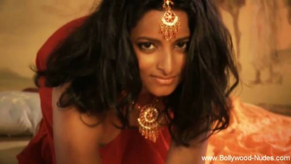 Dark-haired Indian mistress glows in red silk and gold under warm candlelight - India on adultfans.net