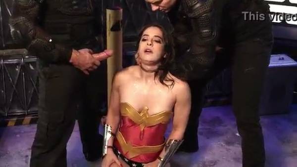Wonder Woman subdued by two captors in a gritty industrial dungeon on adultfans.net