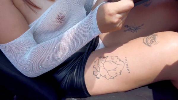Curvy tattooed woman in leather skirt gives stranger oral in car doorway on adultfans.net