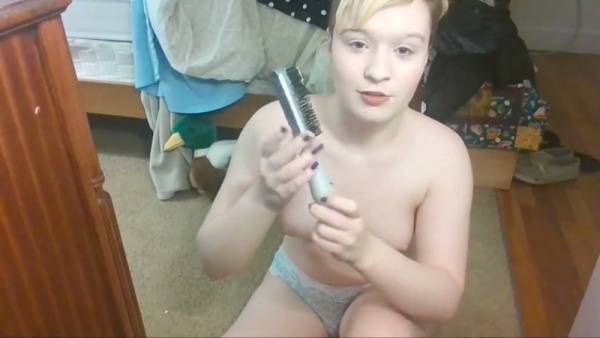 Young woman with pigtails explores her shaved pussy using a hairbrush on adultfans.net