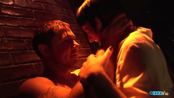 Tattooed lovers entwine in lingerie against dim brick walls under neon lights on adultfans.net
