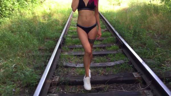 Pink-haired woman takes a man outdoors on a wooden path and railway tracks on adultfans.net