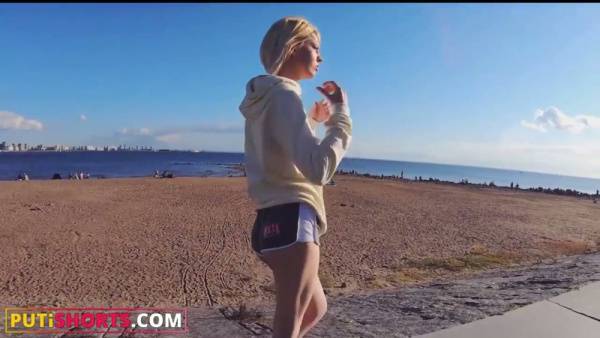 Blonde in athletic shorts spreads for a tattooed man on a white leather couch on adultfans.net