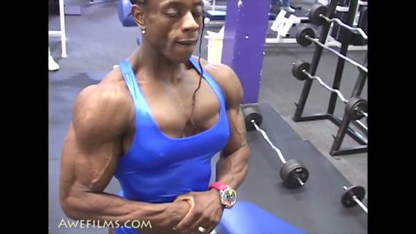 Muscular woman and man showcase defined physiques in intense gym workout on adultfans.net