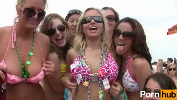Blonde lesbians kiss and embrace at a crowded beach party in matching bikinis on adultfans.net