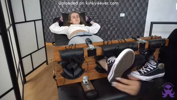 Bound brunette undergoes intense foot tickling session on restraint bench on adultfans.net