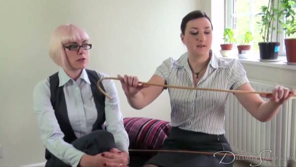 Blonde MILF dominates her pink-haired lover in a fierce cane and paddle session on adultfans.net