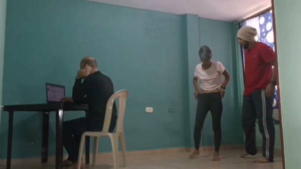 Mature Spanish-speaking men share a quiet moment in a colorful room with teal walls on adultfans.net