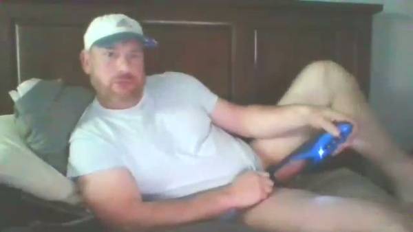 Bearded man explores his limits with a blue phallic toy in bed on adultfans.net